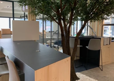 La zone d'attente de l'agence bancaire de Lorgues est aménagée avec du mobilier sur mesure en matière naturelle : bois, galets, sol souple avec écorces de cacaotier, arbre stabilisé. Les teintes sont réfléchies en adéquation avec le mobilier pour proposer des parcours aux clients.